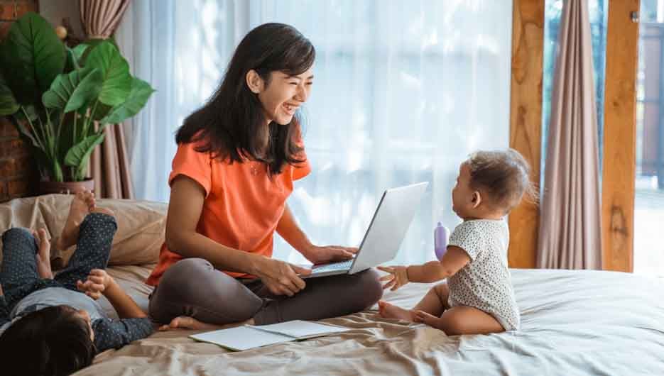 busy businesswoman working while taking care of her children at home
