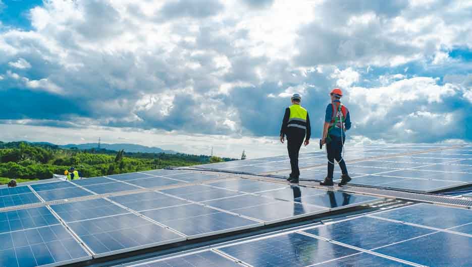 Technician engineer service meeting and checking solar cell on rooftop of industrial factory. Inspection worker repair solar cell panels. Clean Renewable energy, Ecology and alternative power concept