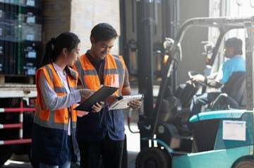 Warehouse worker and manager checks stock and inventory with digital tablet computer in the retail warehouse full of shelves with goods. Working in logistics, Distribution center.
