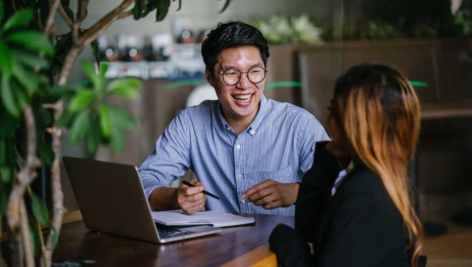 A confident and handsome young man is interviewing a female cand