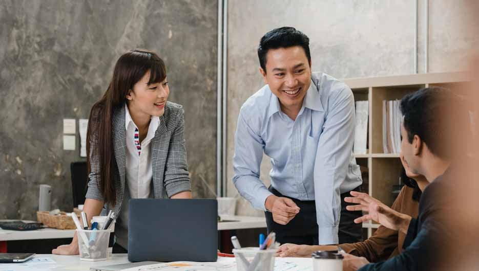 Multiracial group of young creative people in smart casual wear discussing business brainstorming meeting ideas mobile application software design project in modern office. Coworker teamwork concept.