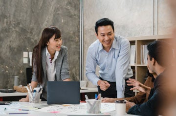 Multiracial group of young creative people in smart casual wear discussing business brainstorming meeting ideas mobile application software design project in modern office. Coworker teamwork concept.